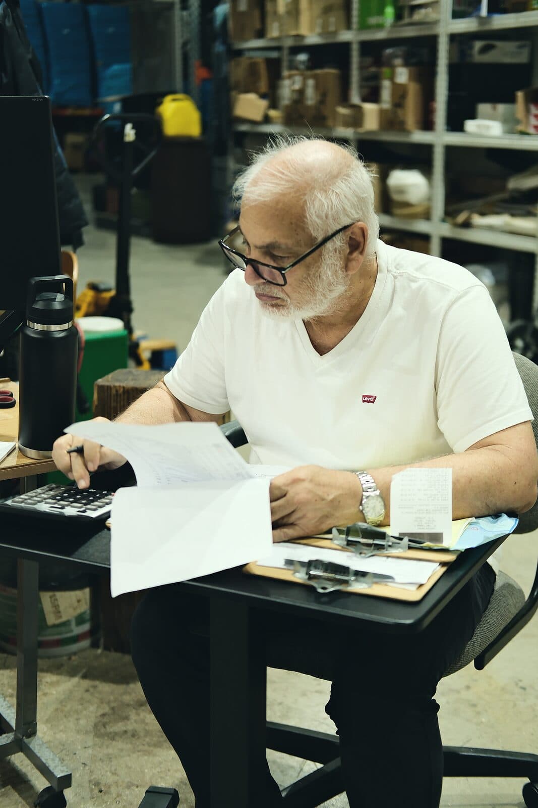 A Samship colleague checking order paperwork at a desk in the warehouse